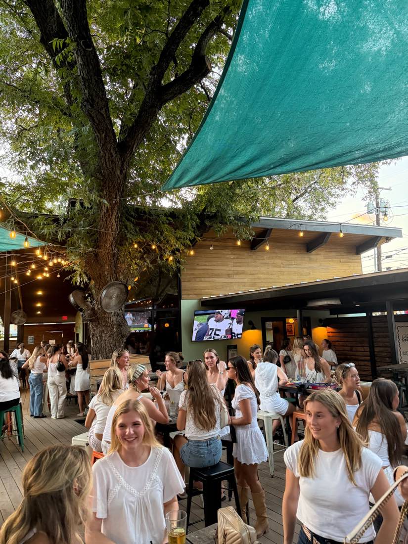Austin Girls Club members at an all-white happy hour on a bar patio