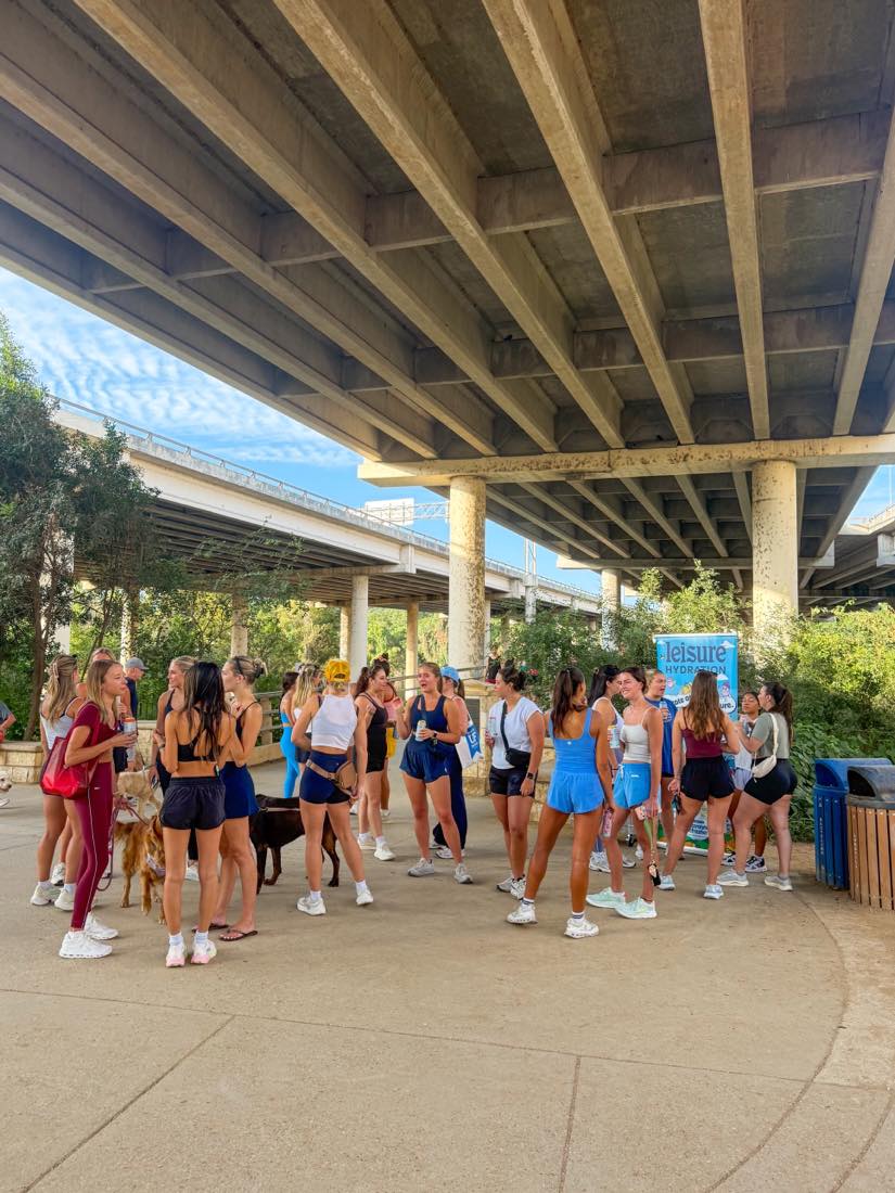 Members gathered under the bridge at the First Saturdays Walk